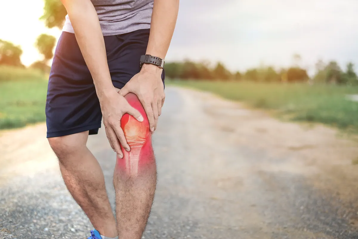 Close-up of person gripping knee with highlighted pain and inflammation around the joint