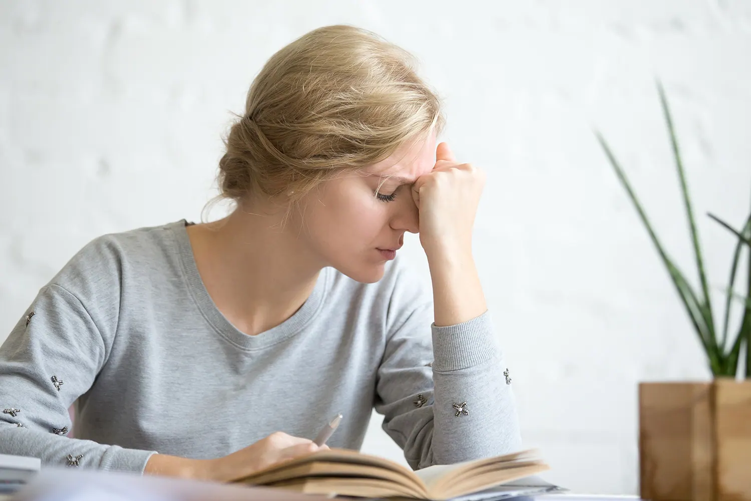 Woman seated with head lowered experiencing dizziness, fatigue, and difficulty concentrating related to vertigo