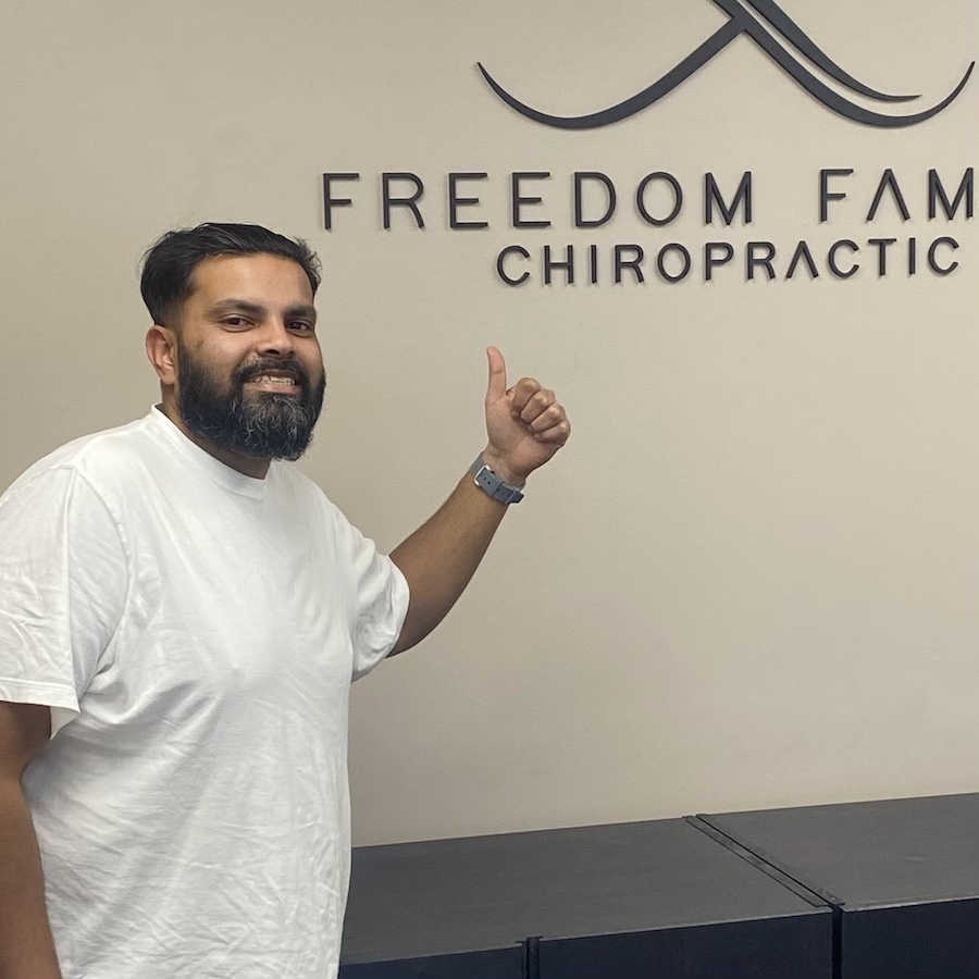 Patient posing in office pointing logo